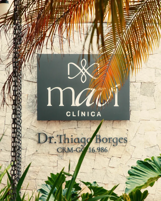 Placa da Clínica Maví na parede de pedra da entrada, com o nome do Dr. Thiago Borges e o CRM-GO 16.986
